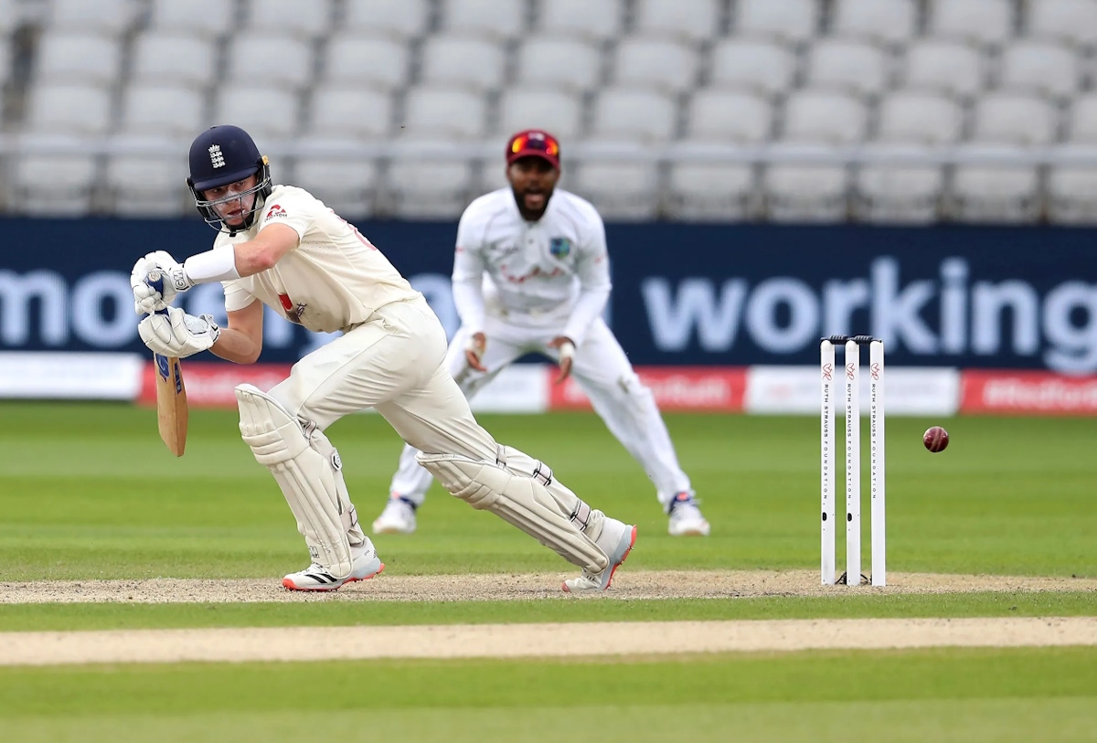 Cricket match in progress at a picturesque English ground