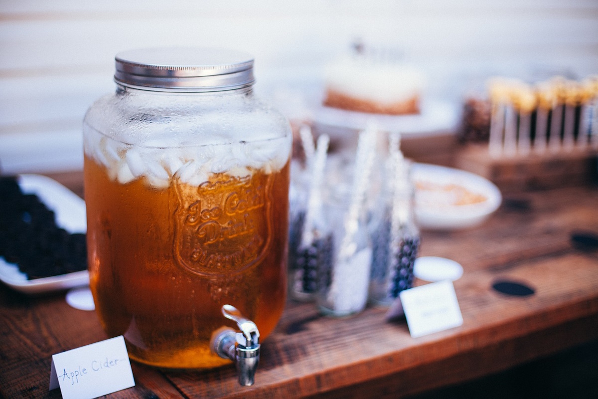 Bottle and glass of cloudy apple cider