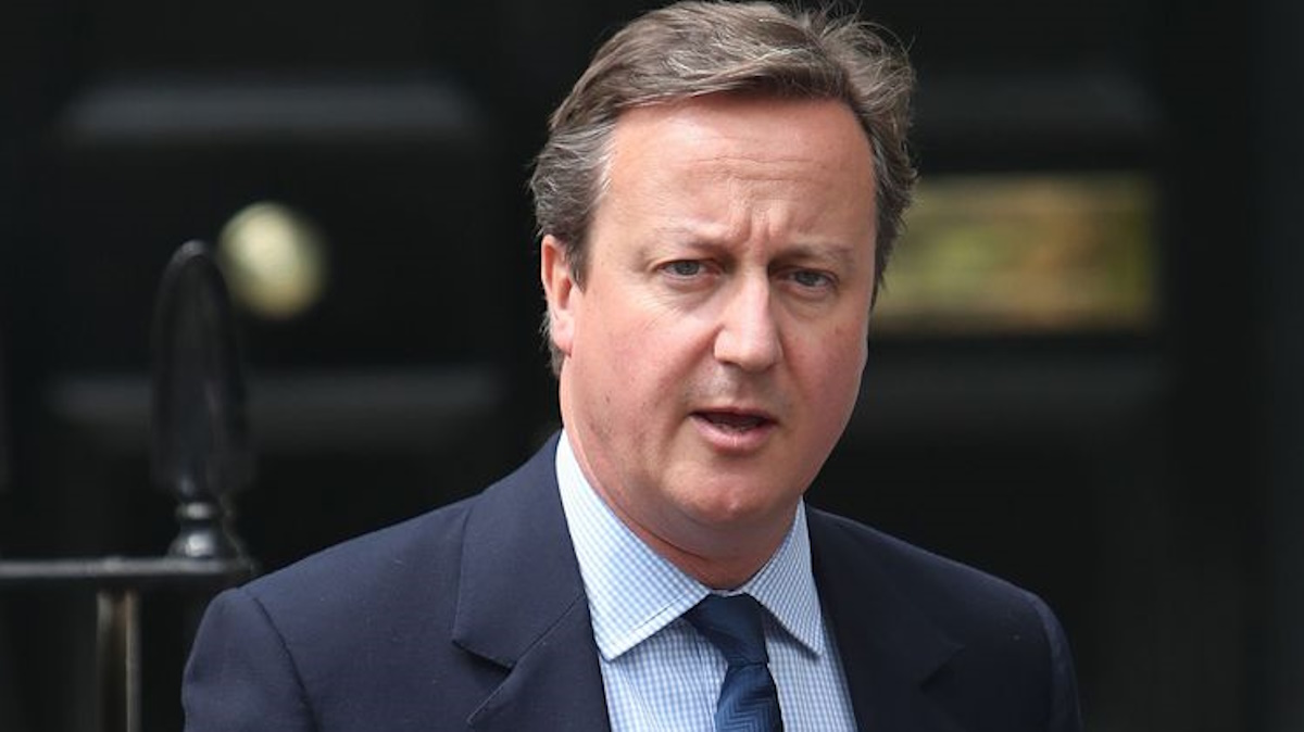 David Cameron speaking at a podium, wearing a navy suit and red tie, 2010s