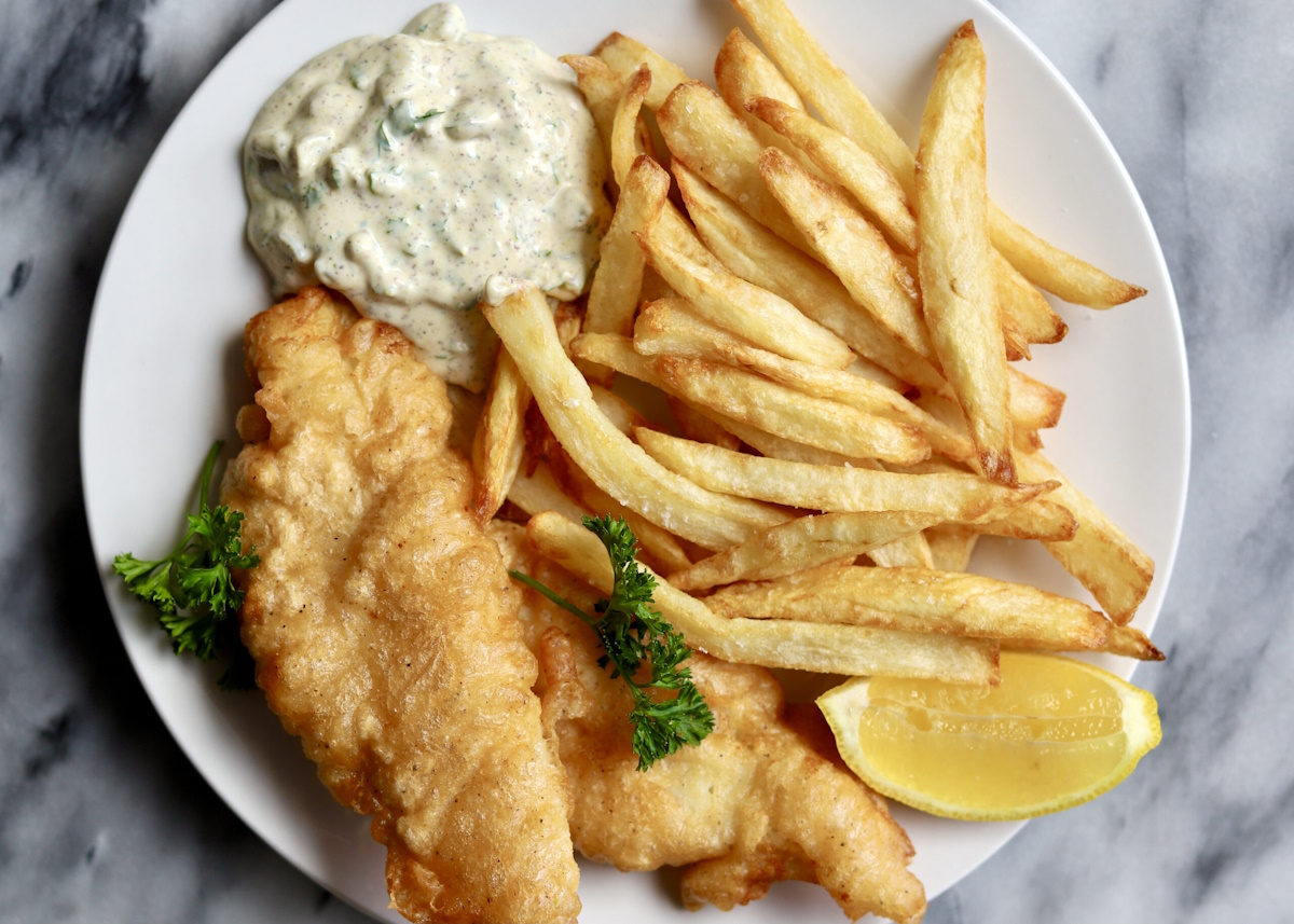 Fish and Chips on a plate with lemon wedge