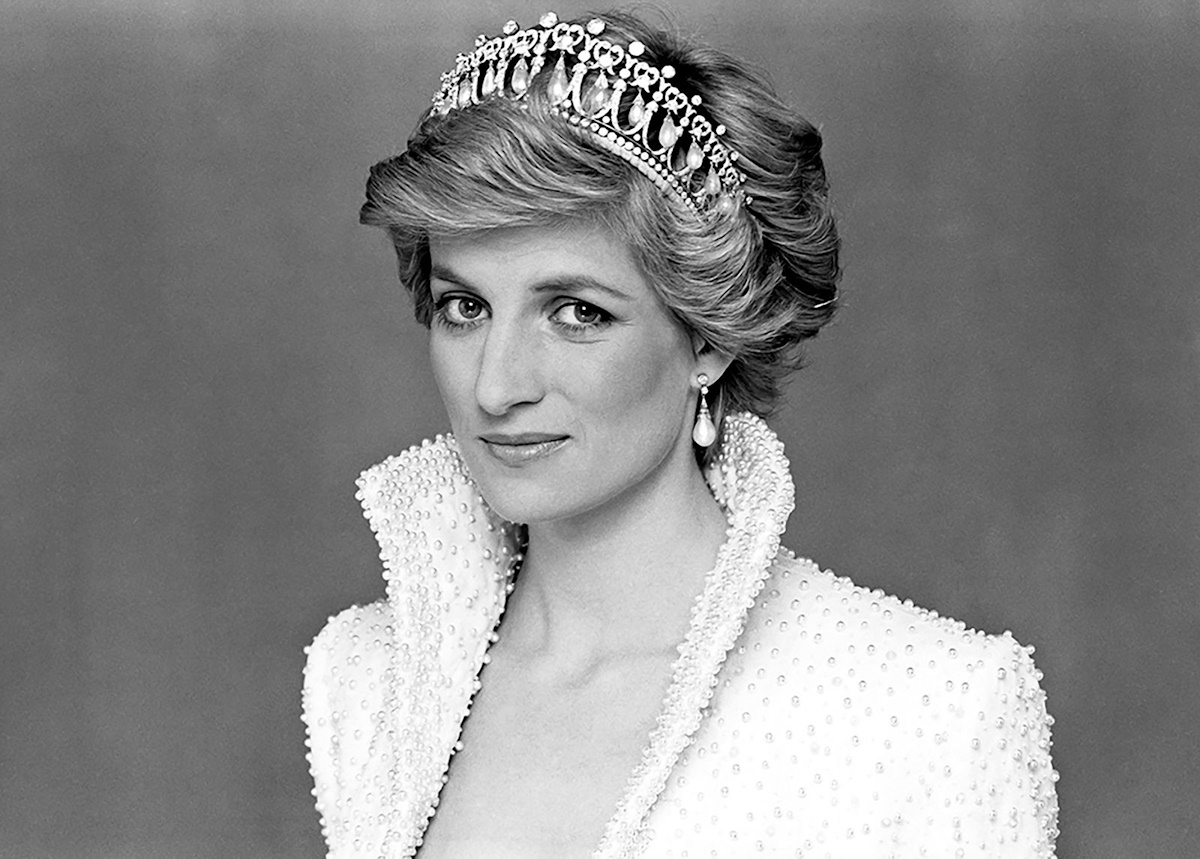 Princess Diana smiling at a public event, wearing a blue dress and pearl necklace, 1990s