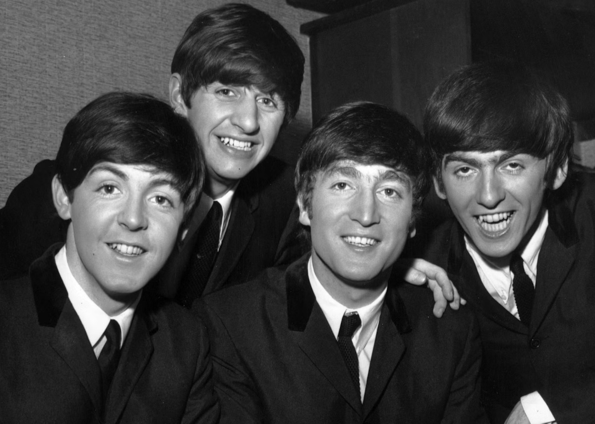 The Beatles performing on stage, black and white photograph